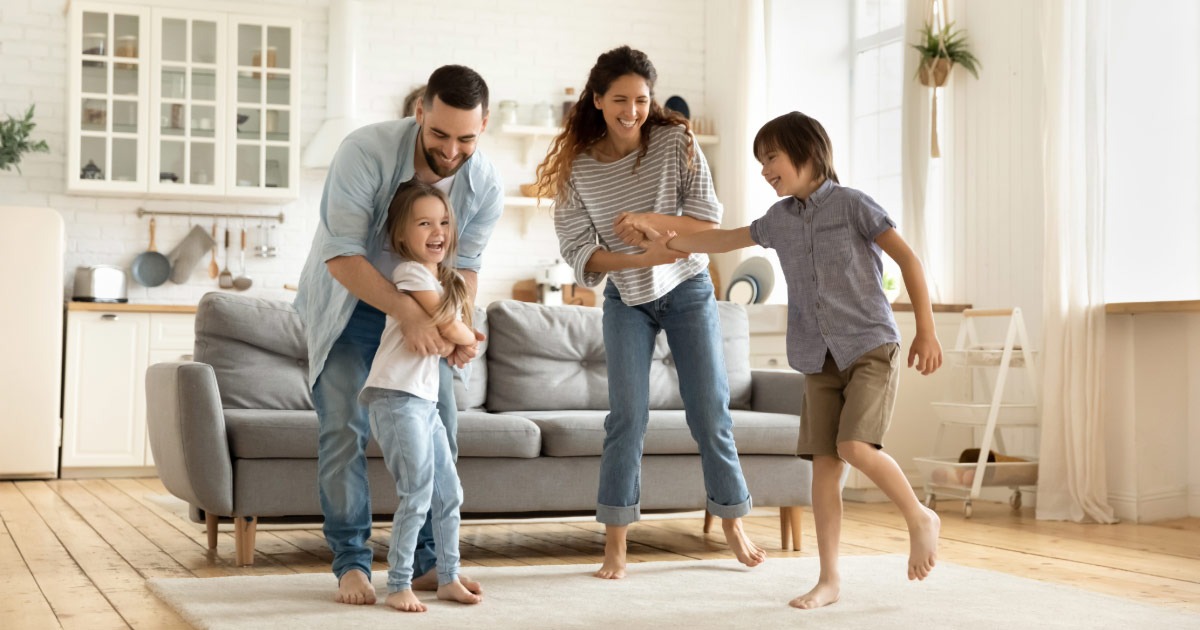 Young family jumping around and playing in living room
