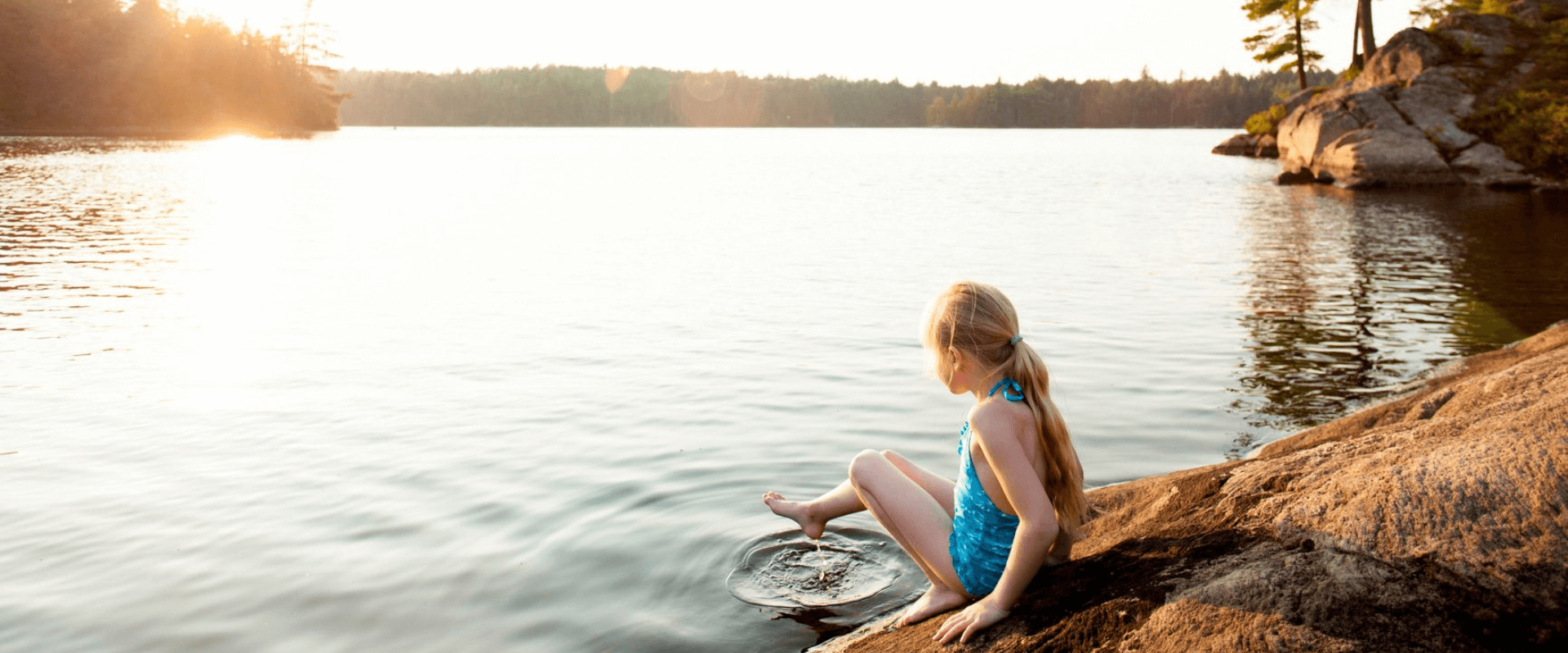 Girl dipping foot into puddle