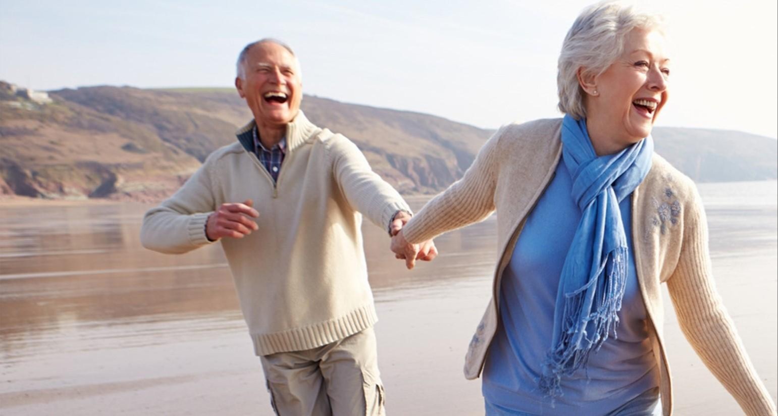Woman and man holding hands on beach
