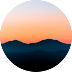 sun setting behind a mountain