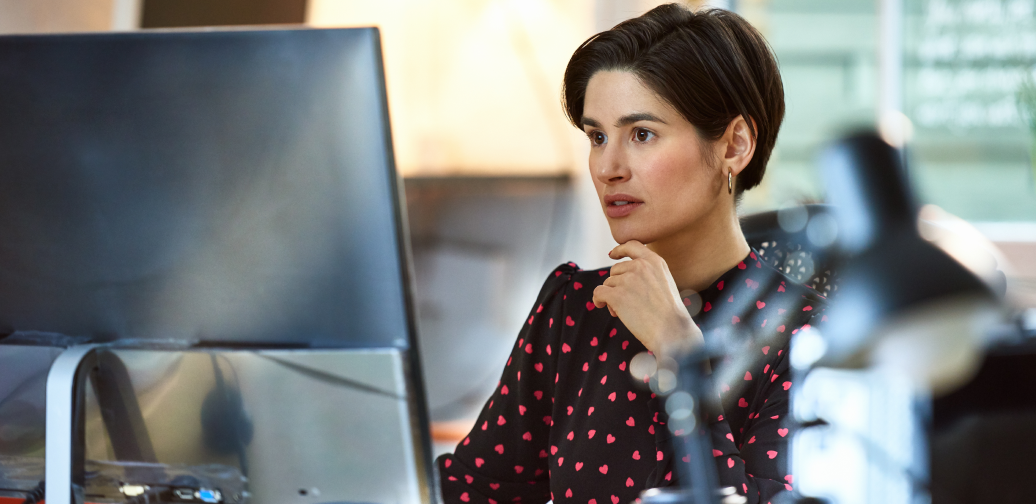 Woman stares at her computer screen contemplating.