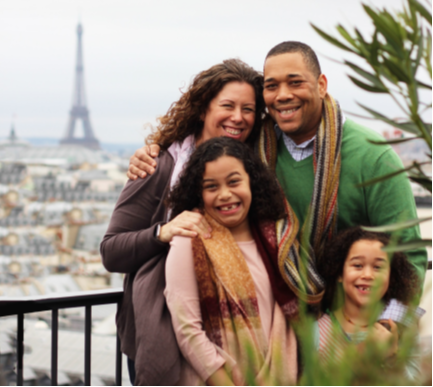 Family of four taking photo infront of eiffel tower