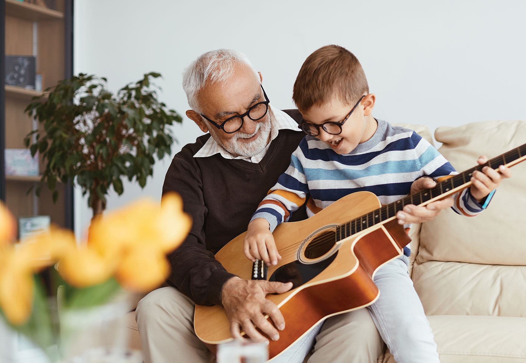 Grandfather teaching guitar to his grandson