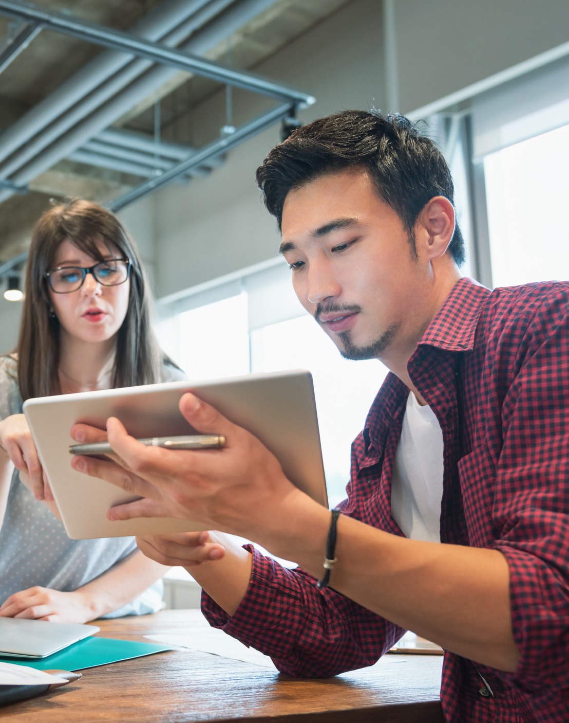 Man showing woman tablet
