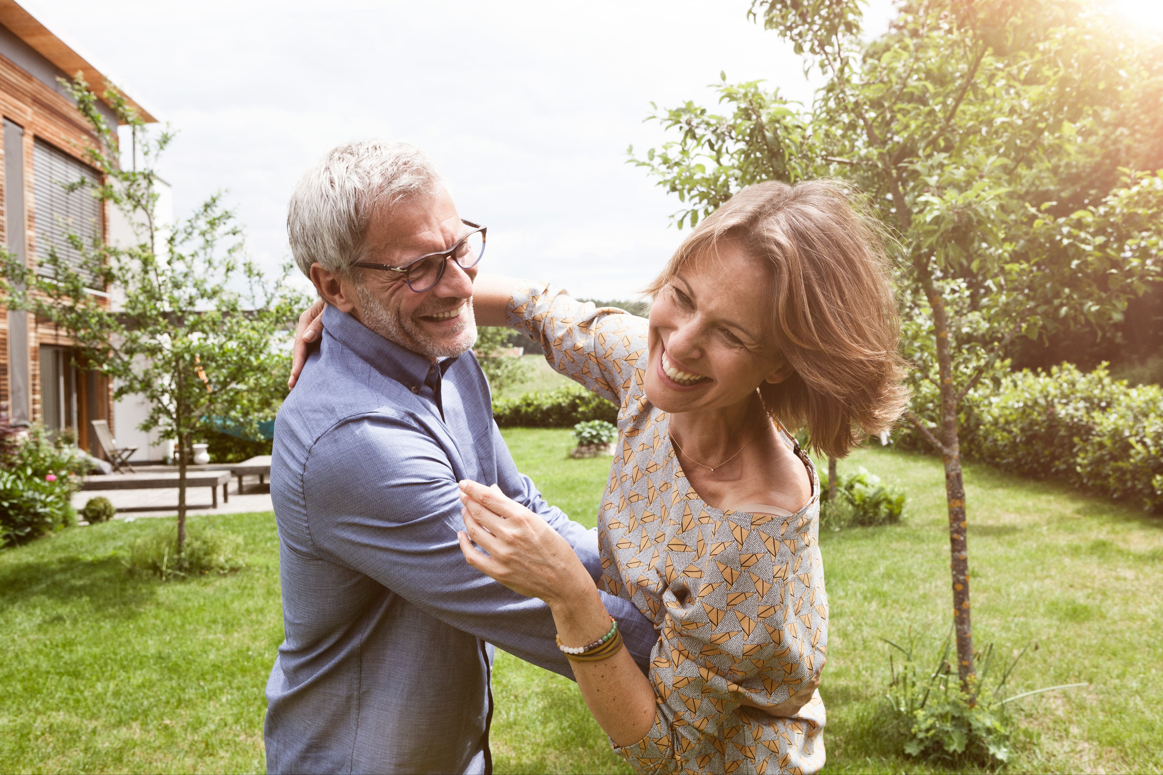 two people dancing in their backyard and laughing