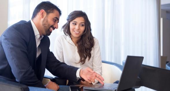 man and woman working together on laptop