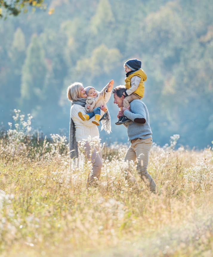 A photo of a couple playing with their grandkids outside