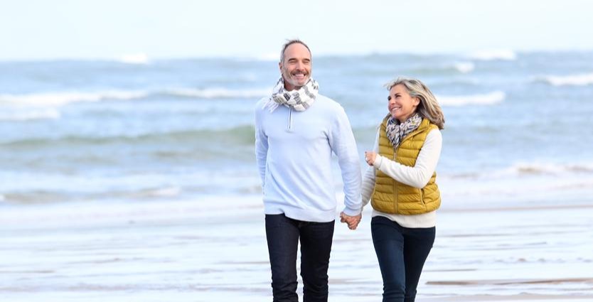 Beach - Retirees, couple walking on the beach holding hands