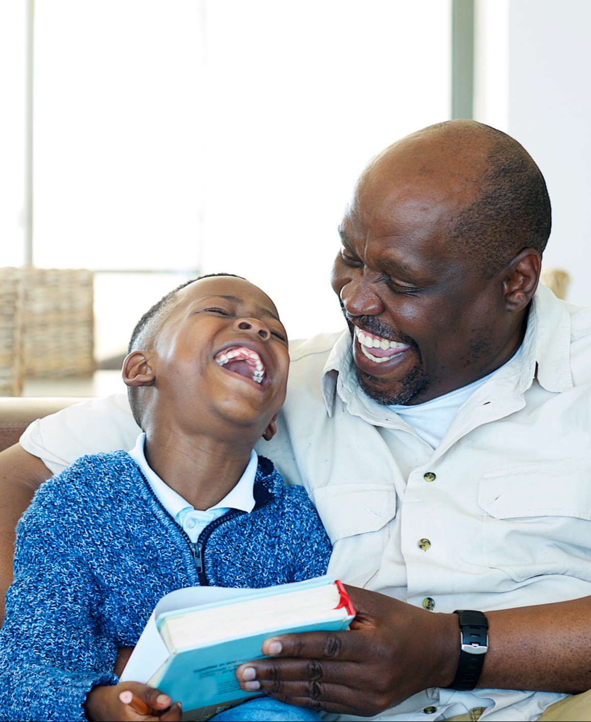 adult and child reading together and laughing