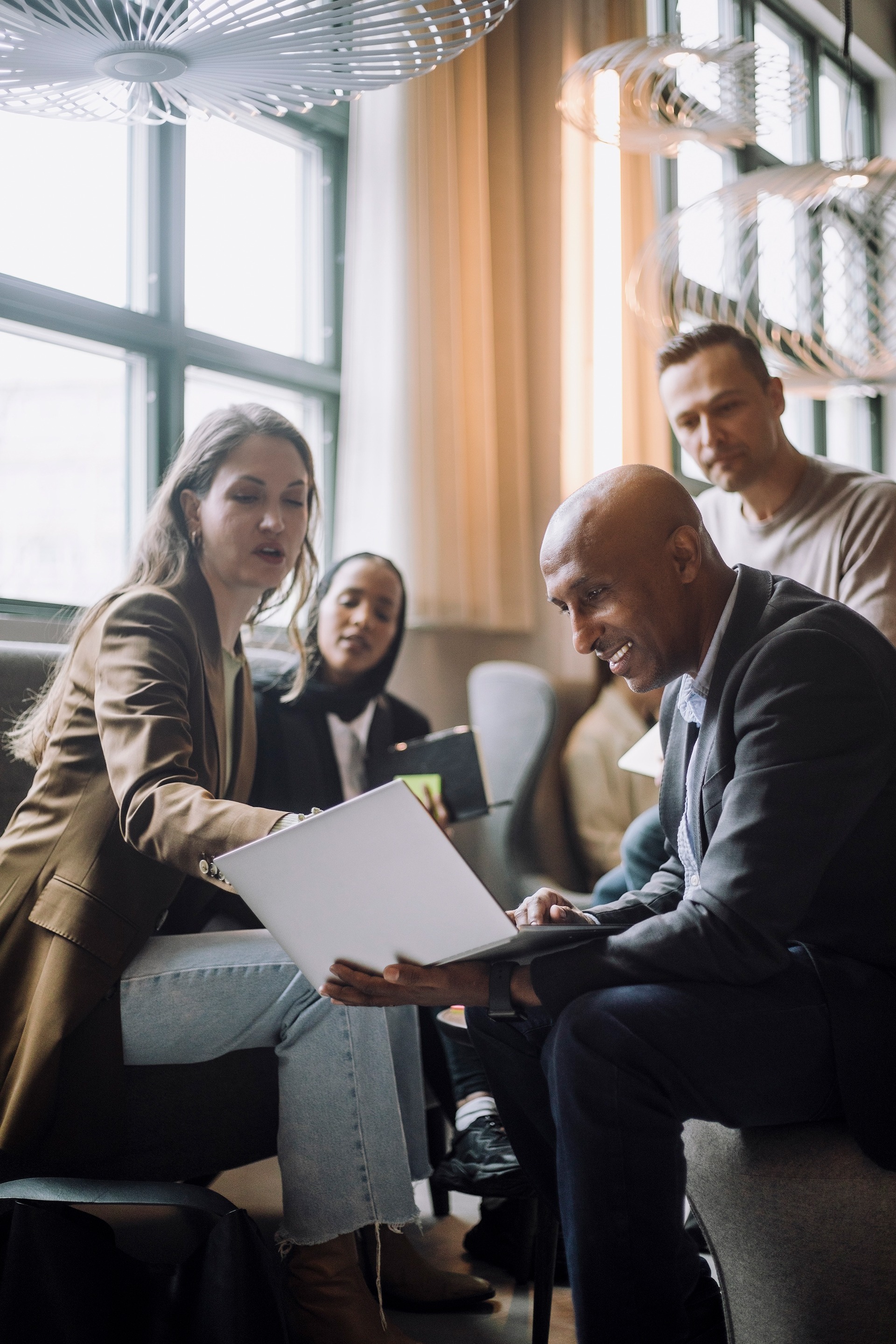 Meeting with four people looking at laptop
