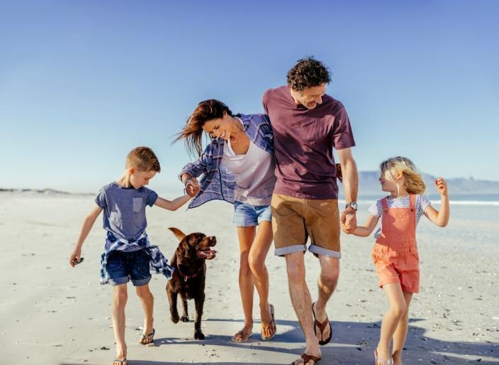 family and their dog enjoying the beach