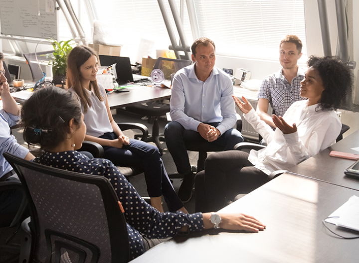 office workers sitting in a circle having a meeting