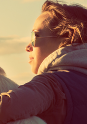 Person with sunglasses on, staring into the sunset