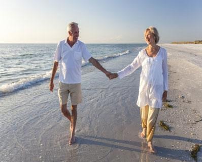 Retired Couple walking down the beach together