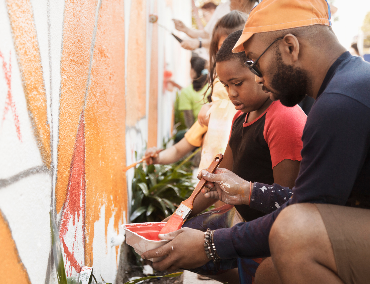 A man and child painting a mural on a wall