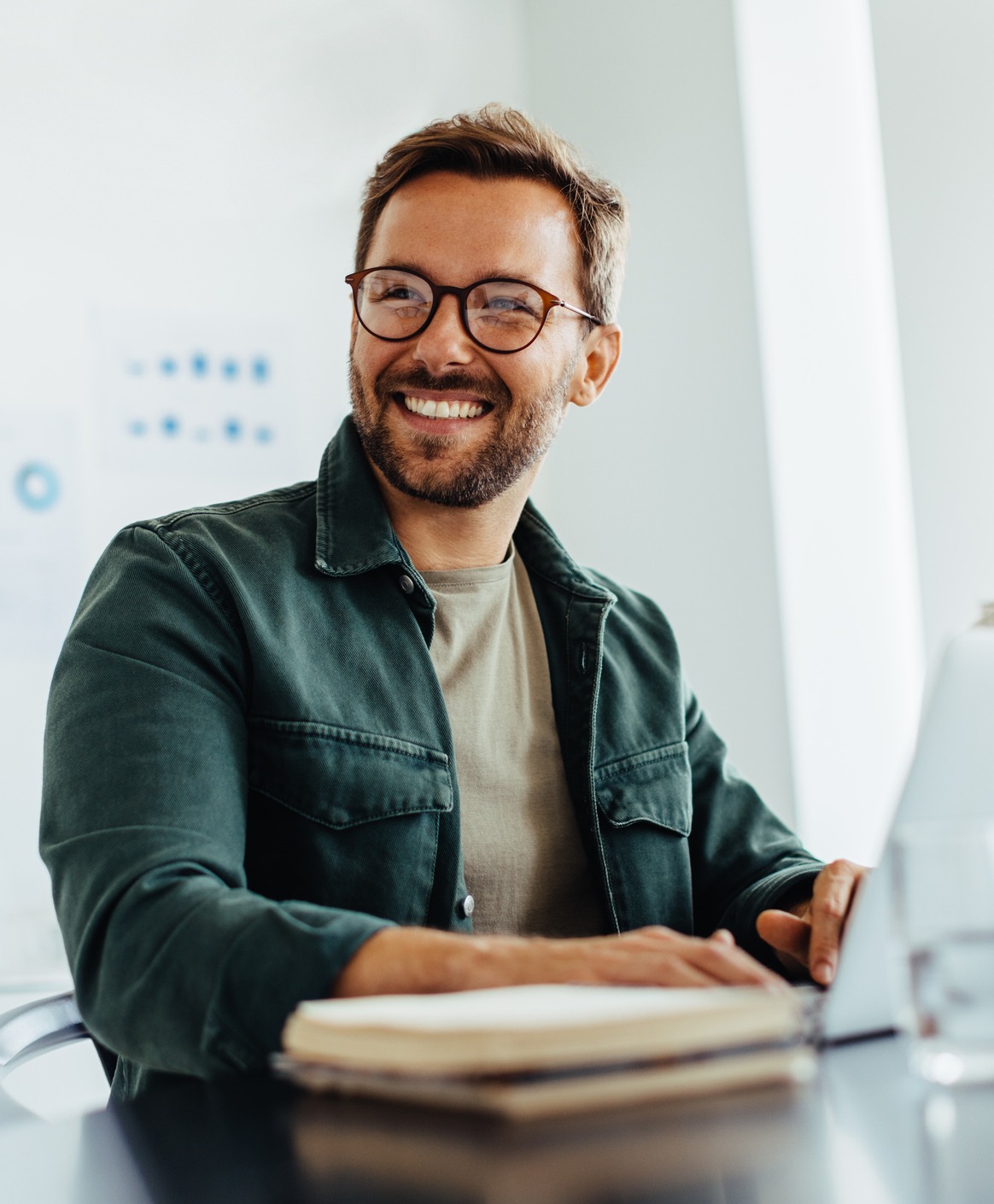 Man smiling while working on laptop
