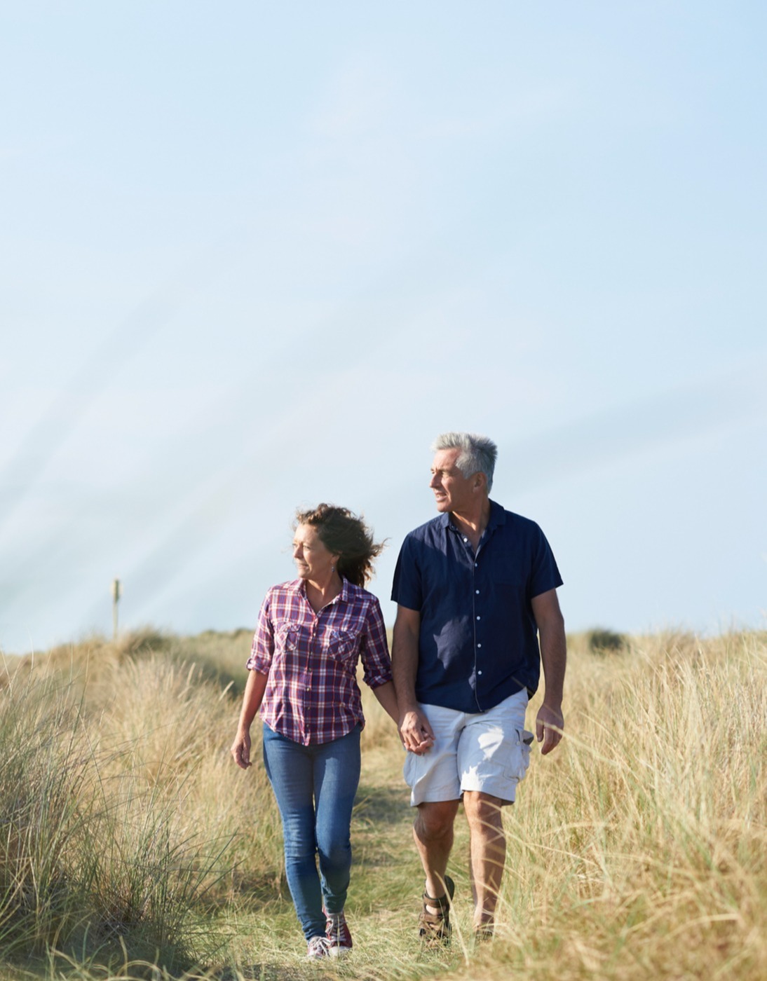 Middle aged couple walking through field