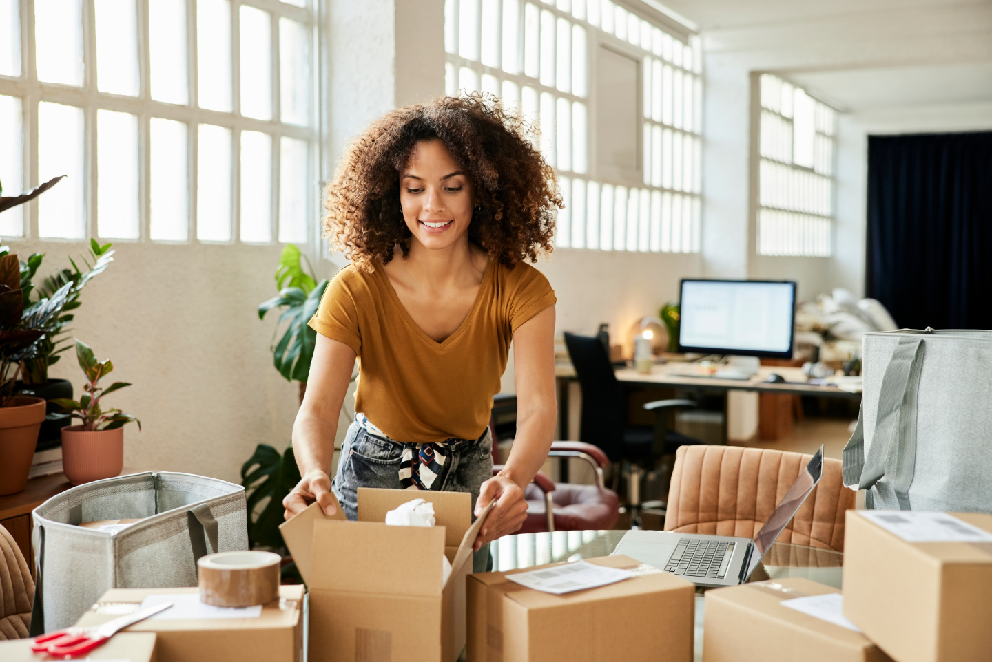 Woman unpacking boxes on a desk in a office
