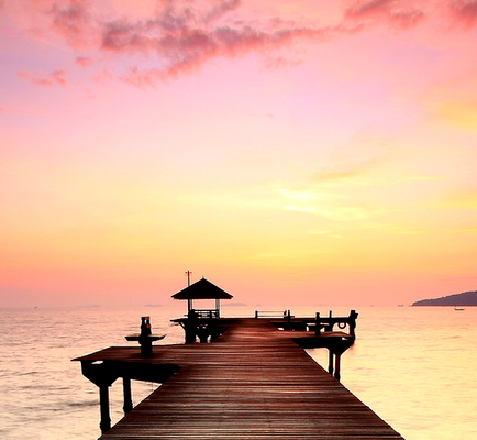 Wooden Dock Above a Body of Water and Under a Beautiful Sunset