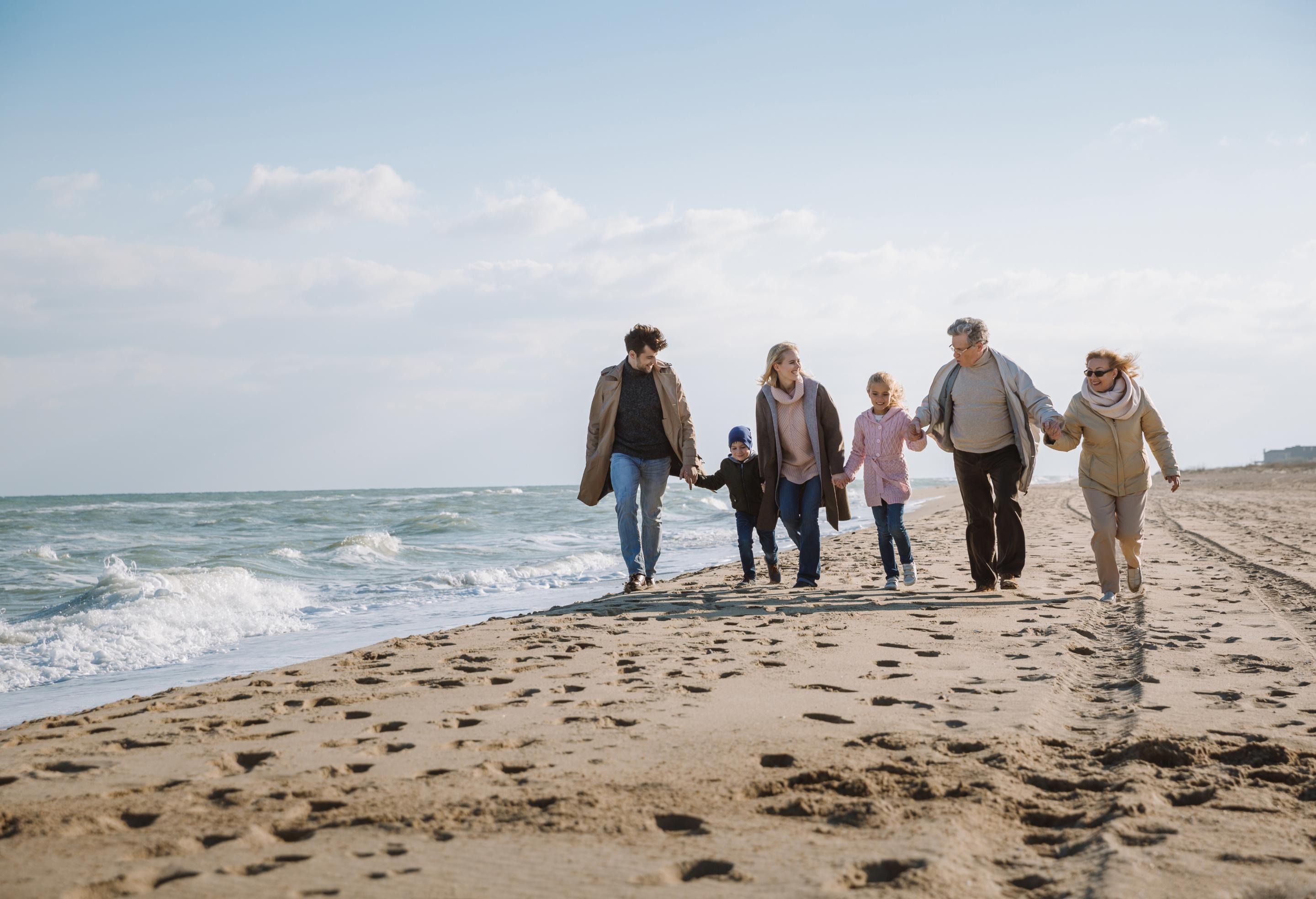 Family walking on beach holding hands