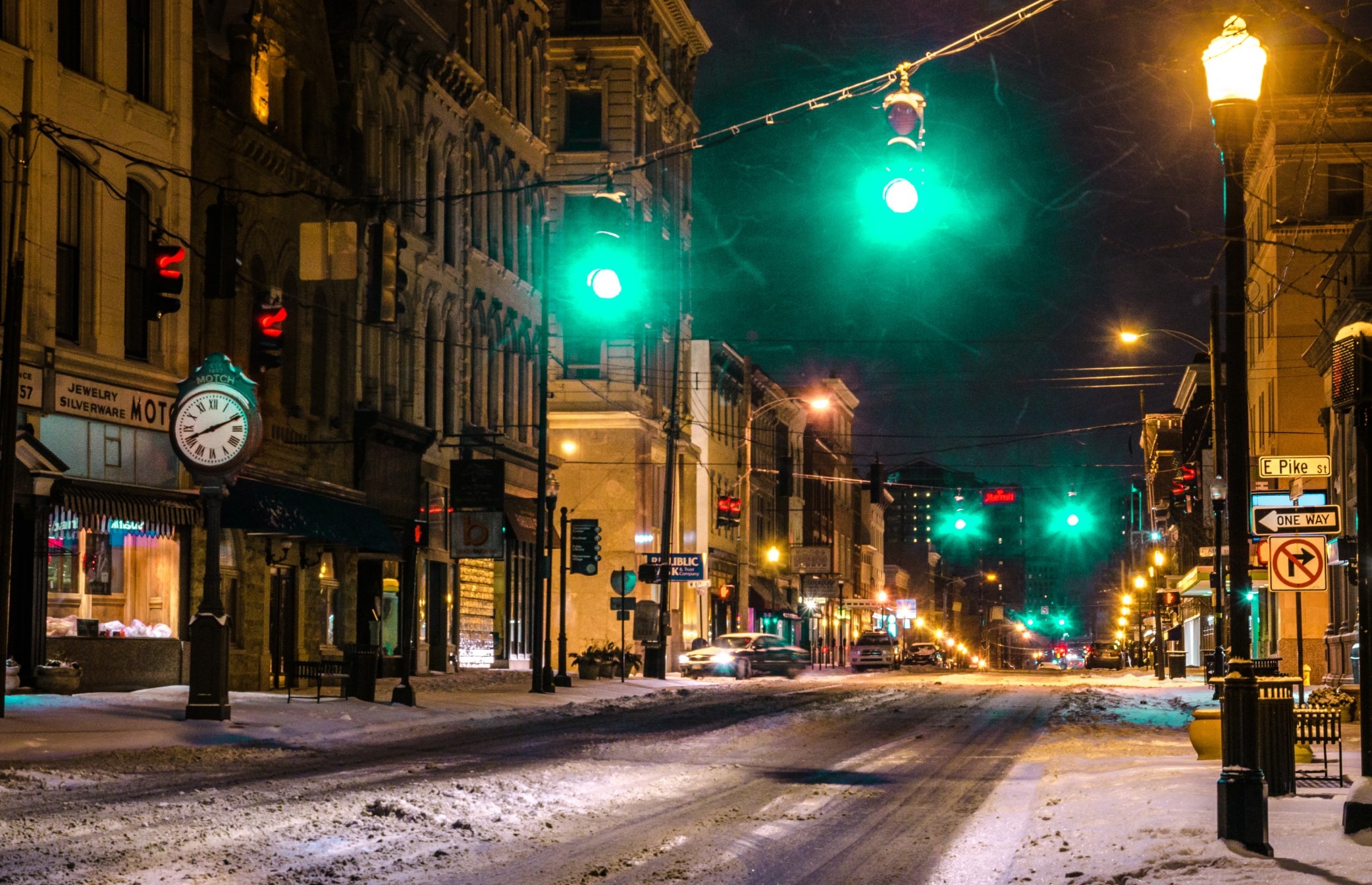 Photo of traffic lights hanging over a snowy city street