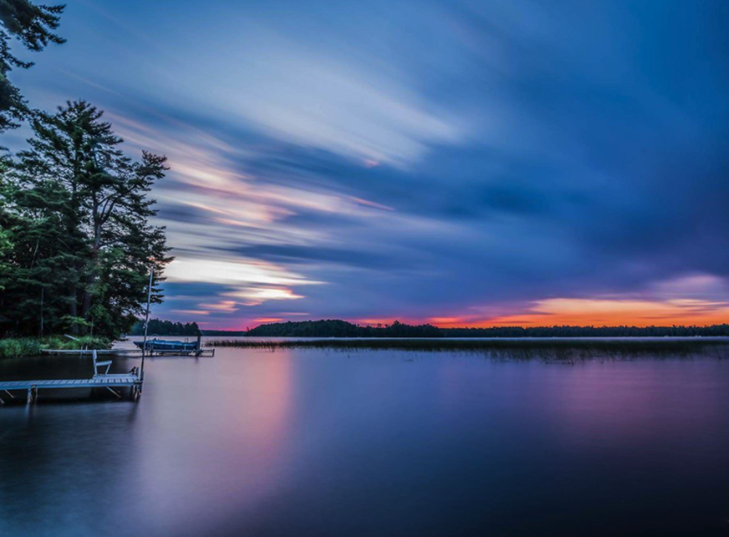 Photo of a body of water with the sun setting in the background.