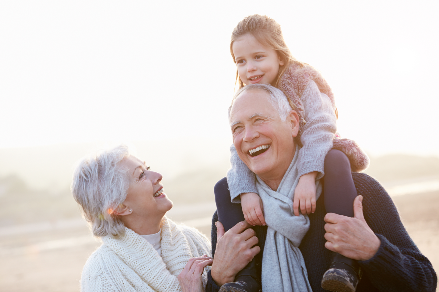 grandparents and their grandchild enjoying eachother's company outdoors