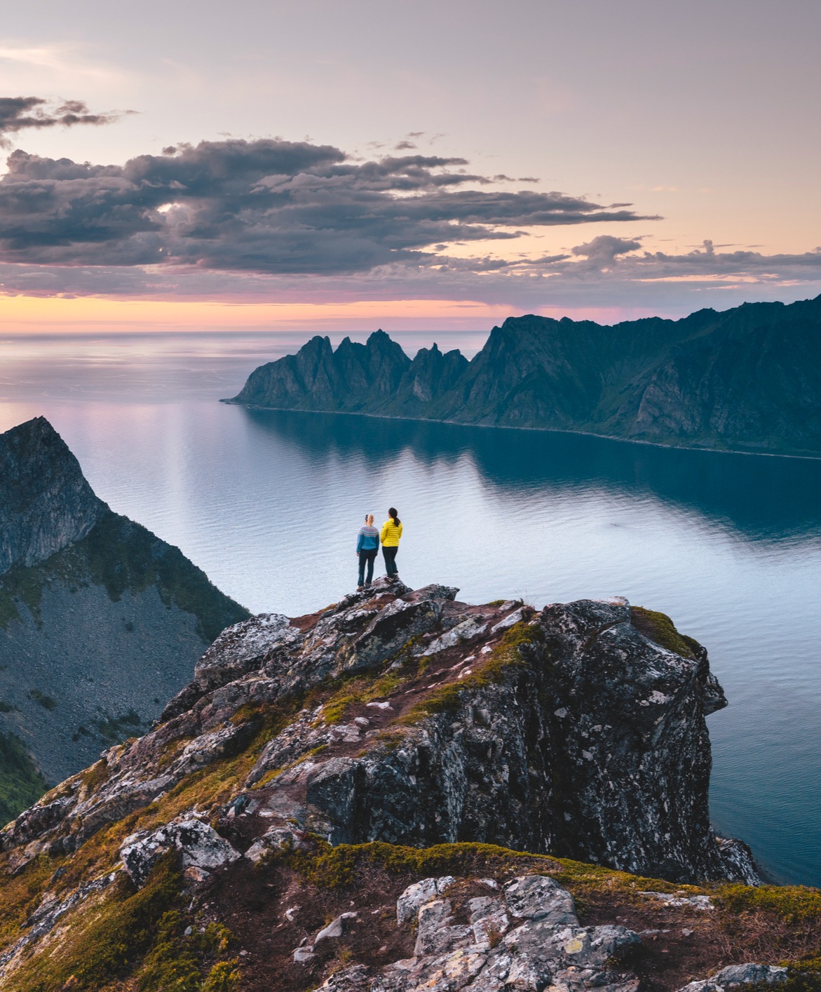 2 women standing on a cliff overlooking the ocean