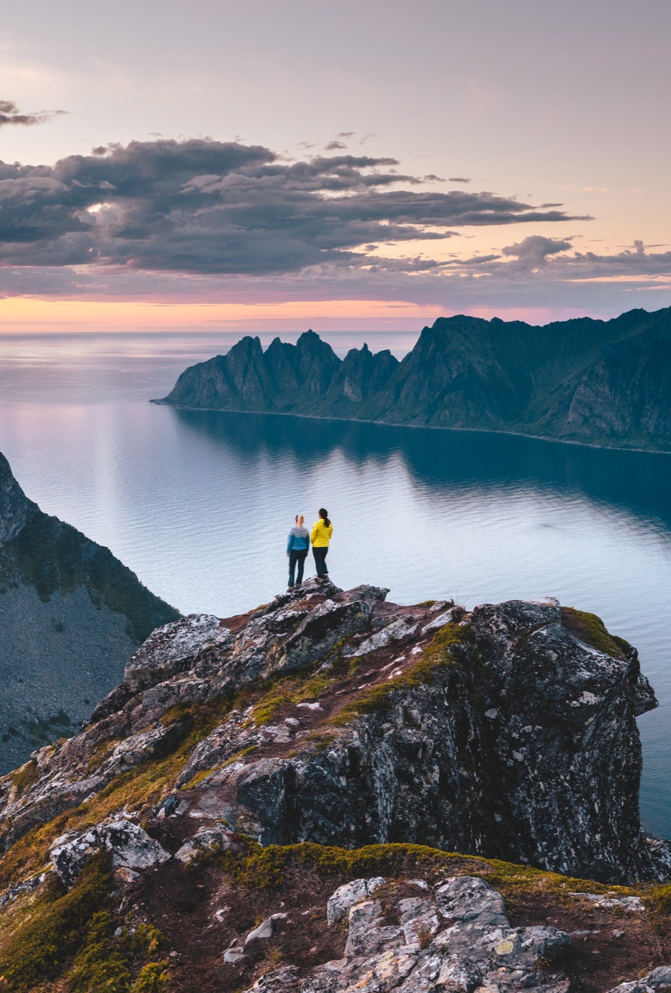 Hikers enjoying the view of a lake from large rock