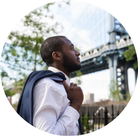 Man with suit jacket over shoulder outside