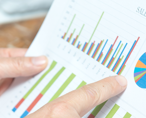 Person holding a document with graphs depicted