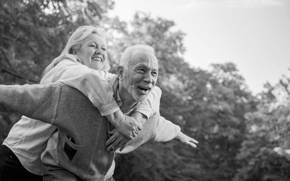 Man piggybacking a woman while smiling