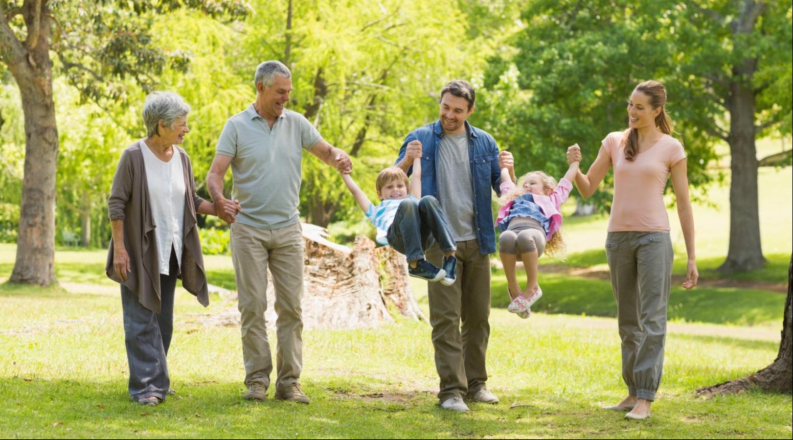 Extended family walking together through the park