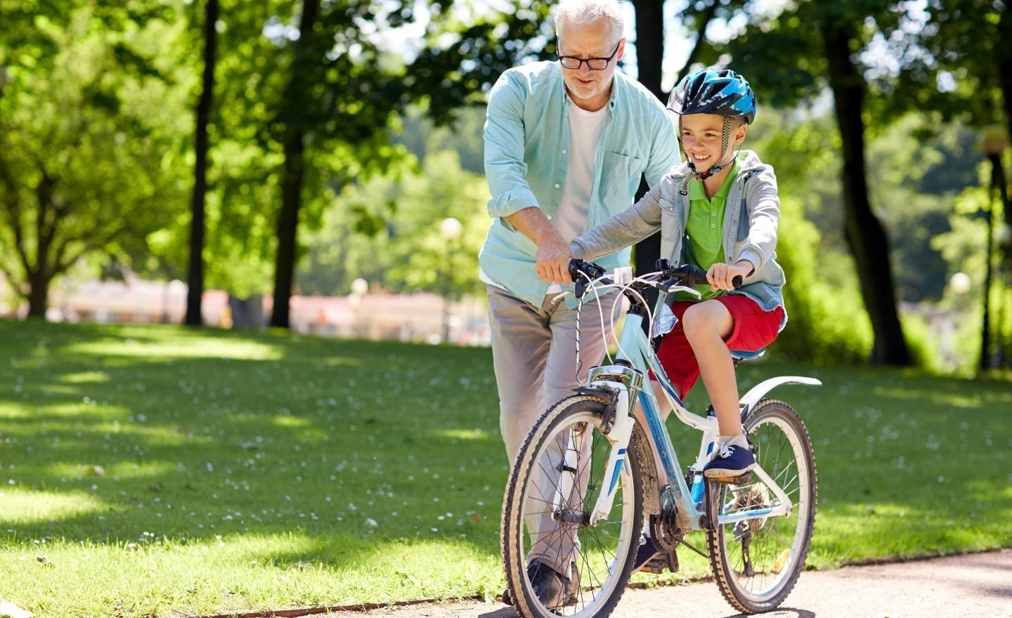 grandpa teching cycling to a kid
