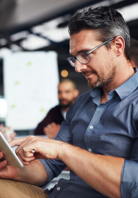 In Office - Millenial Man doing business on a tablet computer