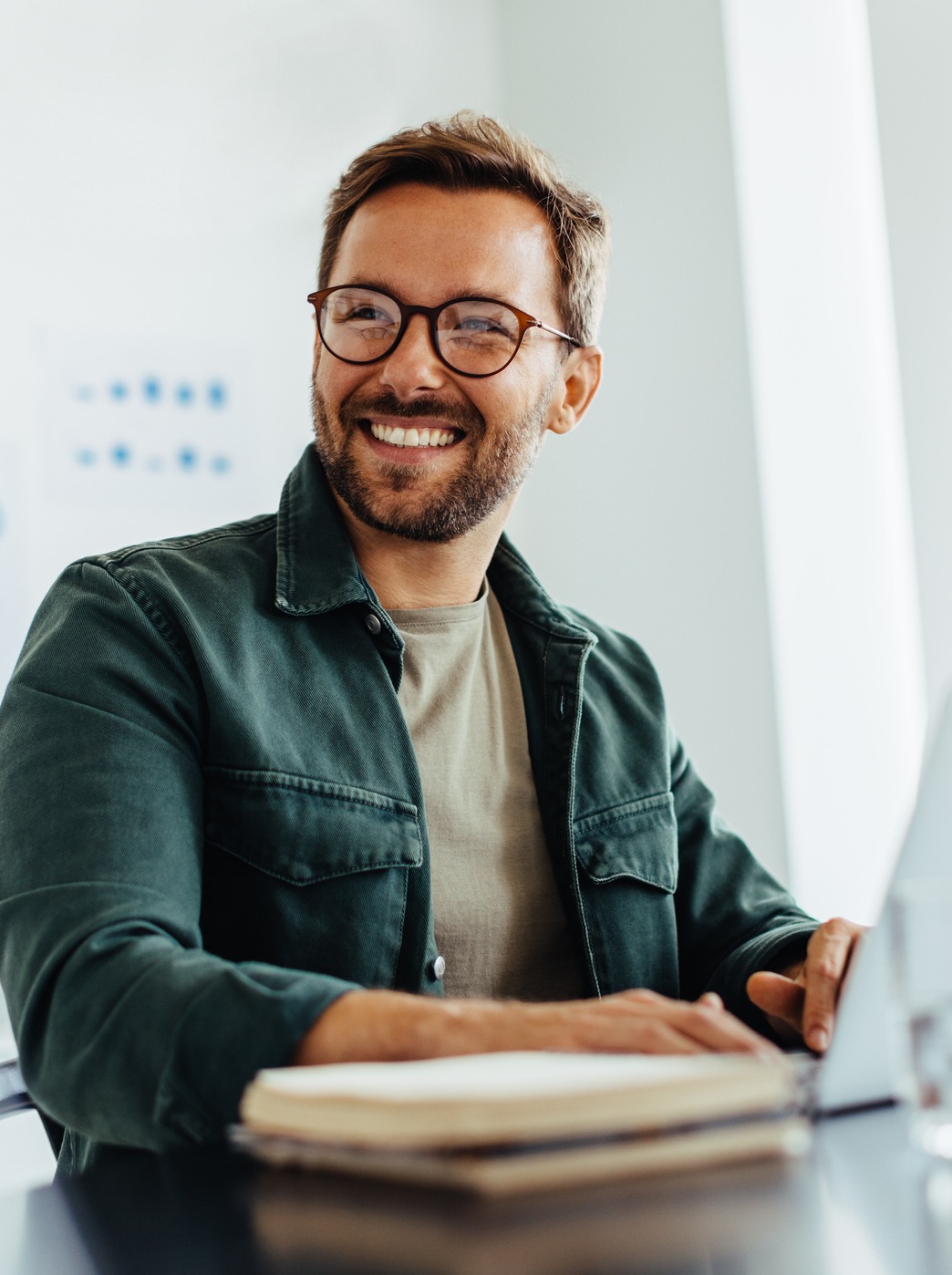 man working on laptop and smiling