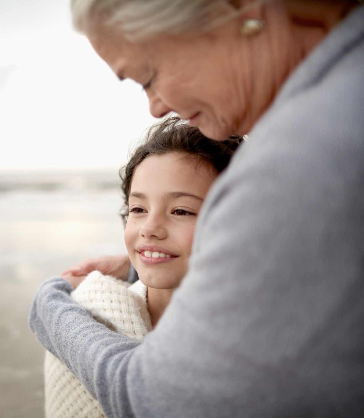 Grandmother hugging daughter on a beach