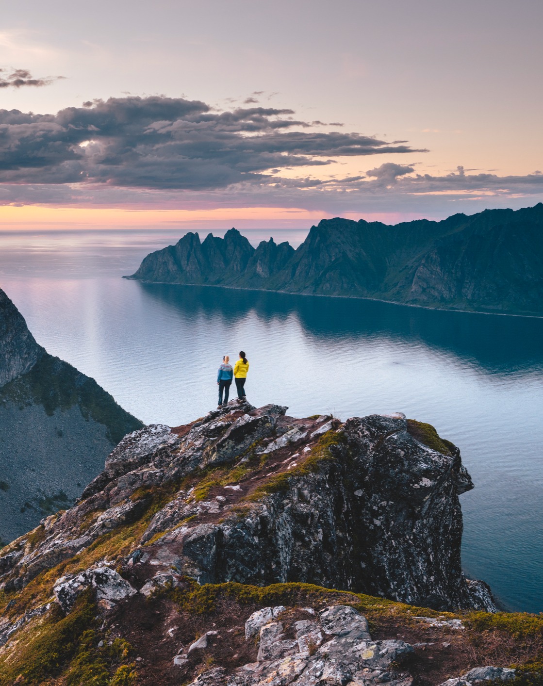 Two hikers on top of a mountain enjoying the view