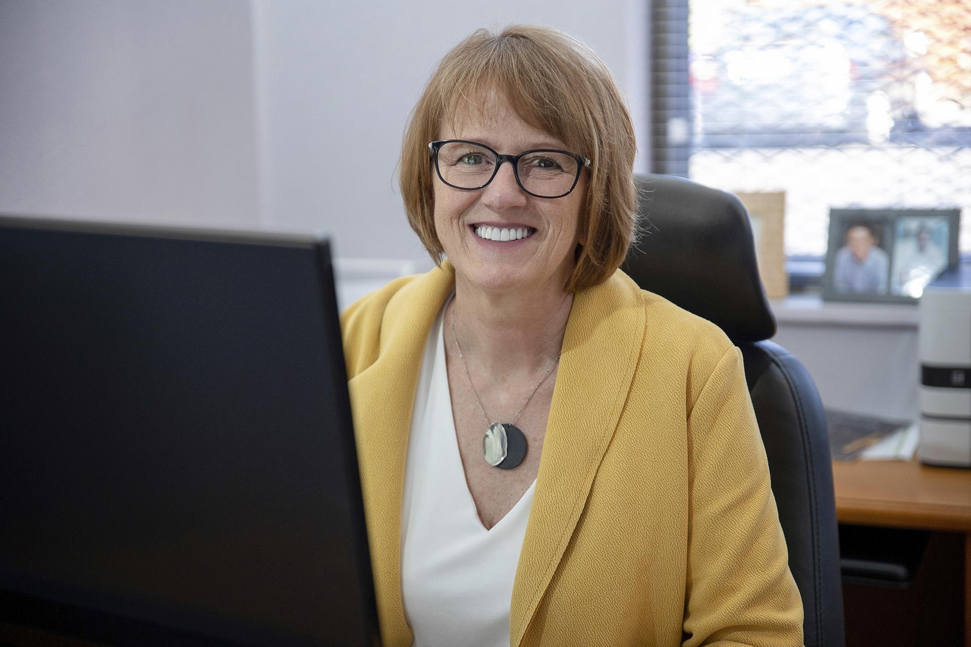 woman sitting at a computer and smiling