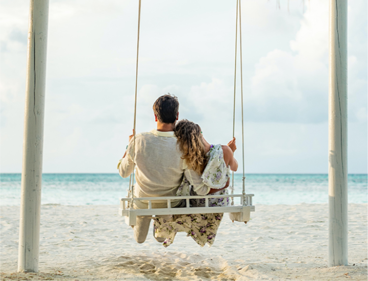 couple-swinging-together-on-a-beach