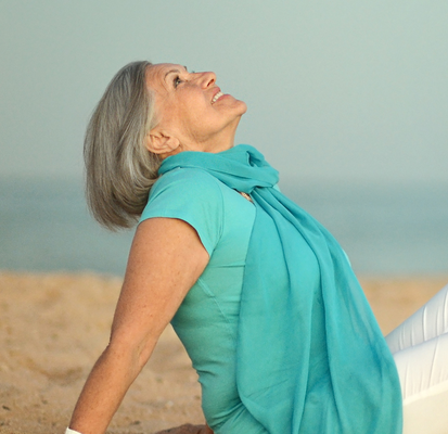 Woman sitting on a beach enjoying life.