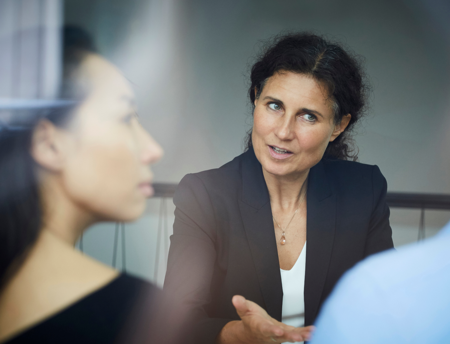 two women listening to someone speaking during a meeting