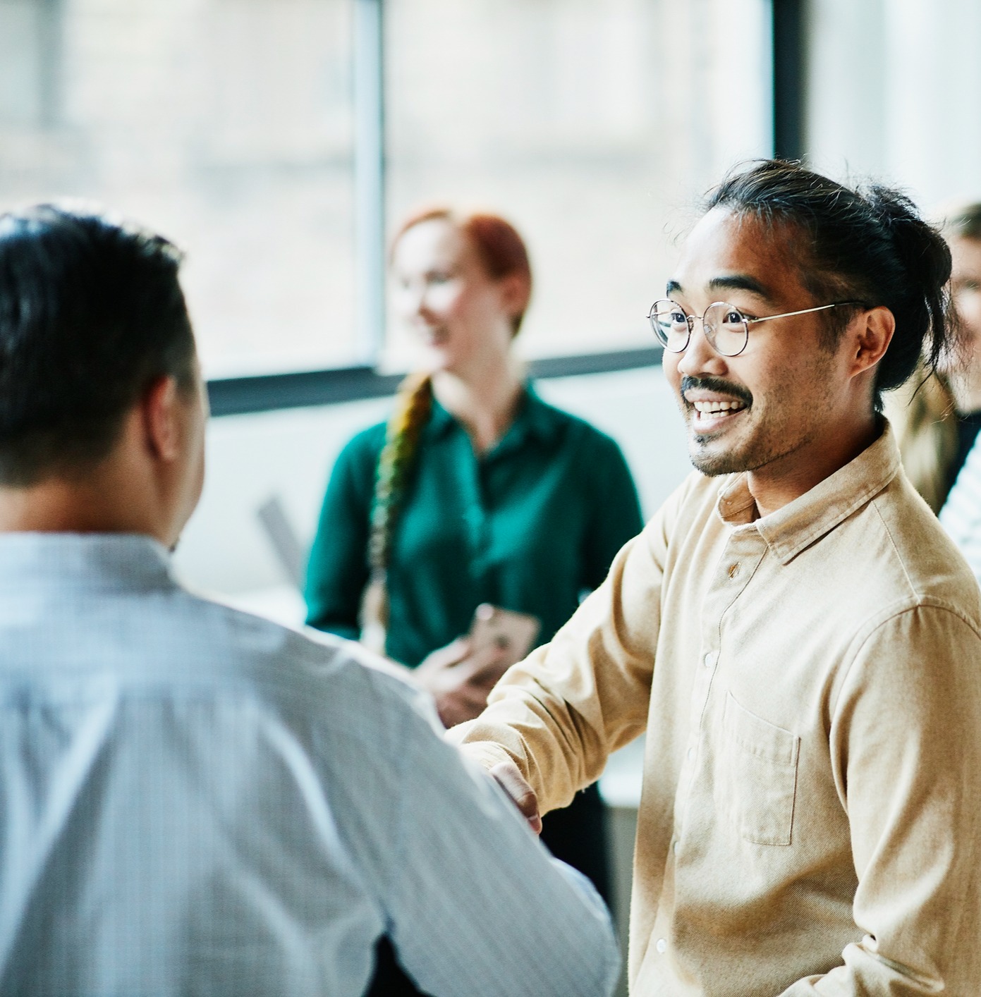 Two men smiling and shaking hands