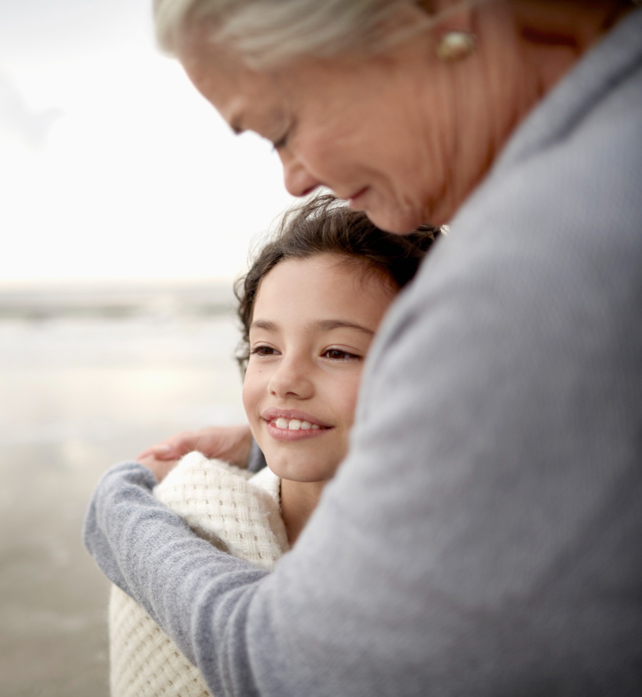 woman hugging a child on a beach