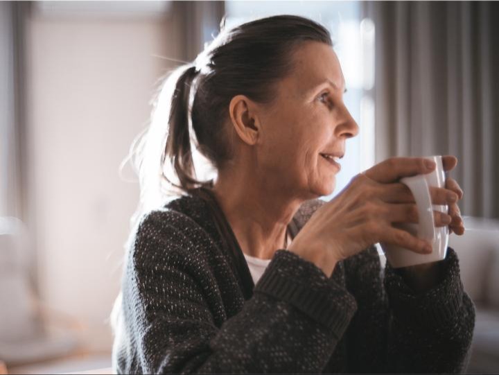 woman drinking a cup of coffee and smiling