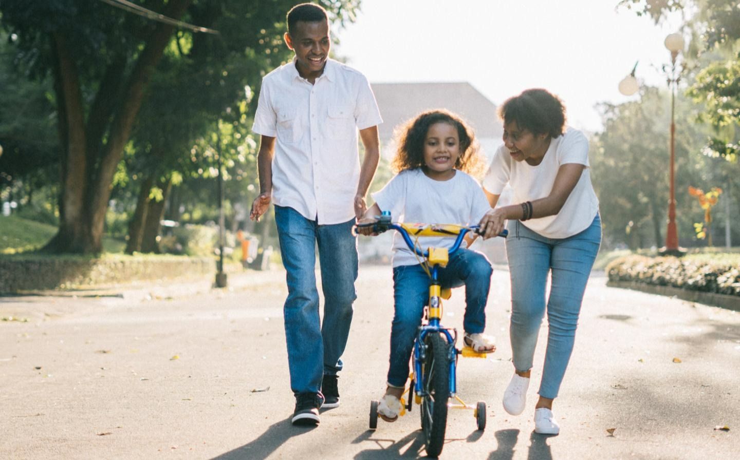 Parents teaching their child to ride a bike