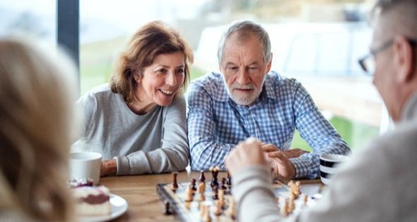 couple playing chess with friends
