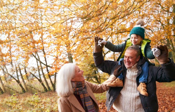 Outdoor garden – Multigeneration, a child helps their grandparent plant a seedling while wearing matching blue jeans