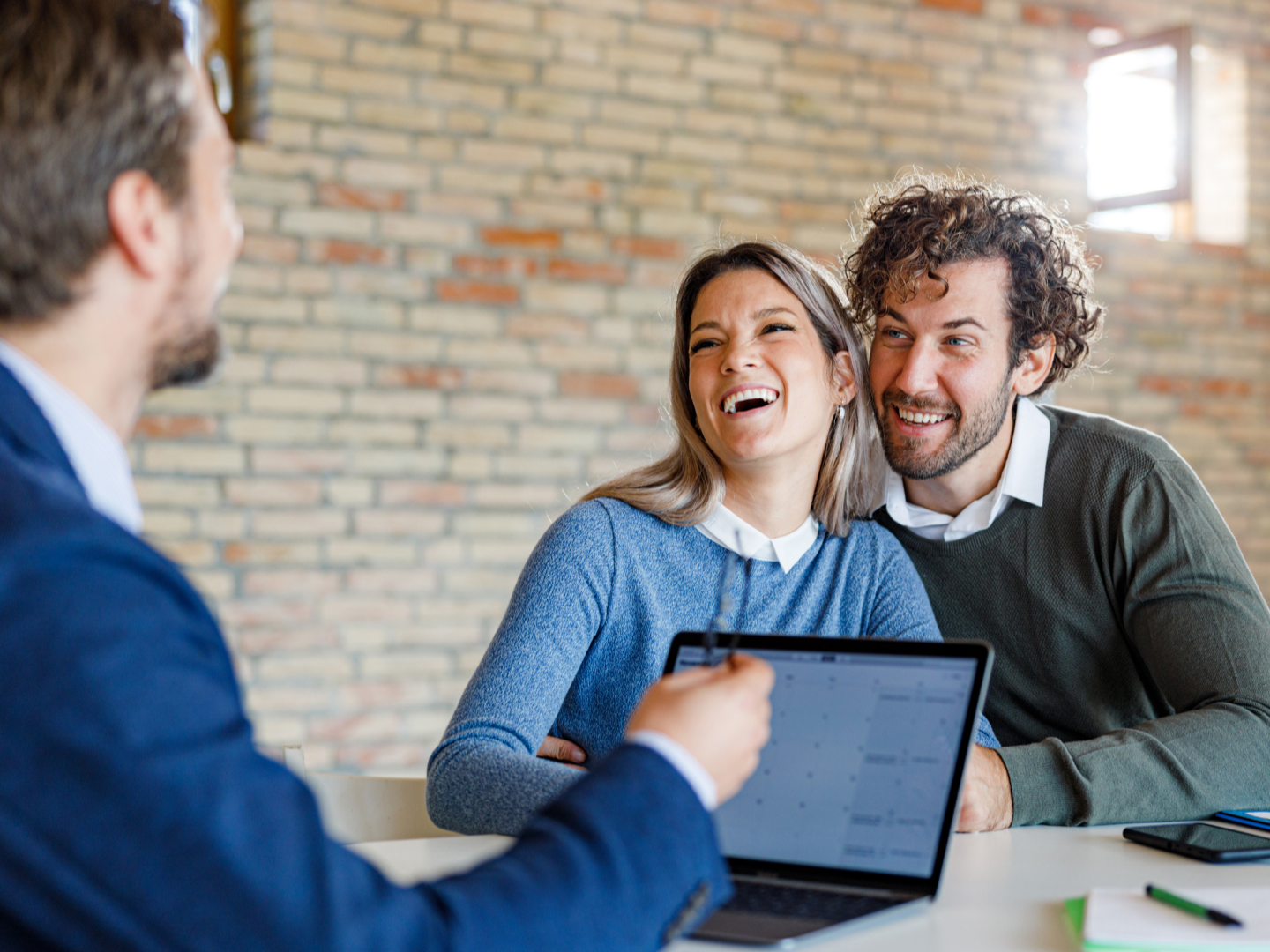 Couple talking with their financial advisor and smiling