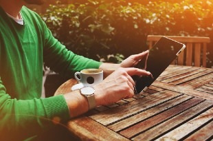 Man with tablet at cafe.